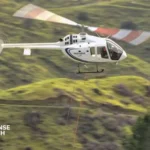 Bell 505 light helicopter in flight configured for military pilot training missions