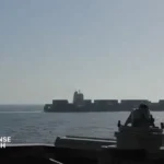 U.S. Navy guided-missile destroyer USS Spruance monitoring the disabled Iranian-flagged cargo vessel M/V Touska in the Arabian Sea following a maritime interdiction operation, April 2026.