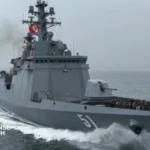 North Korean leader inspecting a newly unveiled nuclear-capable warship during a military ceremony at a naval shipyard.
