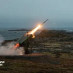 NASAMS air defense launcher and Sentinel radar system deployed during a missile defense exercise in a desert environment.