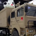 Chinese Silent Hunter mobile laser air defense system displayed or positioned near Abu Dhabi Airport facilities, highlighting its 6x6 truck-mounted configuration for rapid deployment.