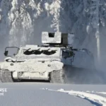 Patria TRACKX tracked armored vehicle maneuvering through Arctic terrain during joint Finnish and Swedish military evaluation activities.